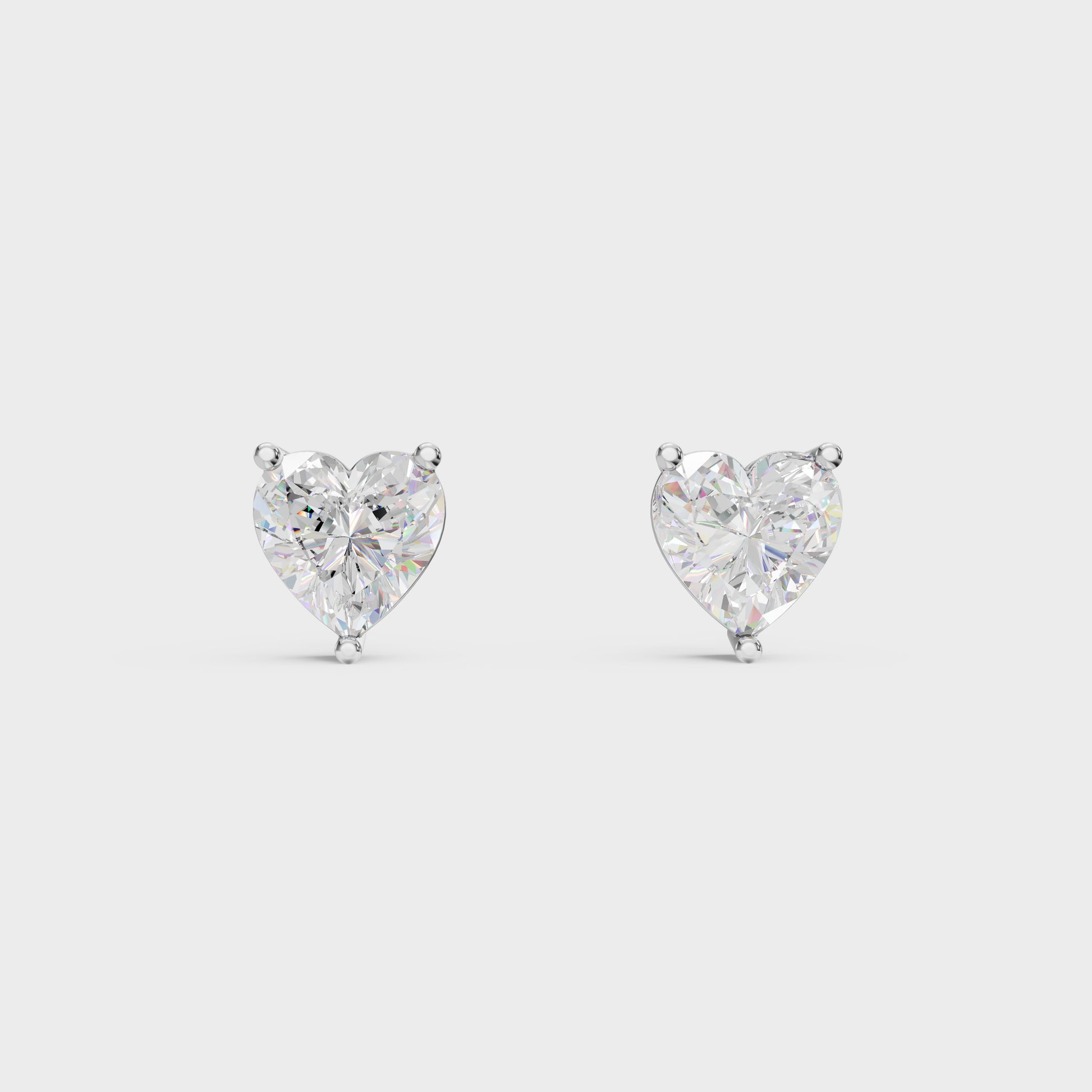 Heart-shaped diamond earrings on a light gray background