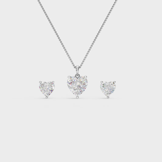 Heart-shaped diamond necklace and earrings on a light gray background