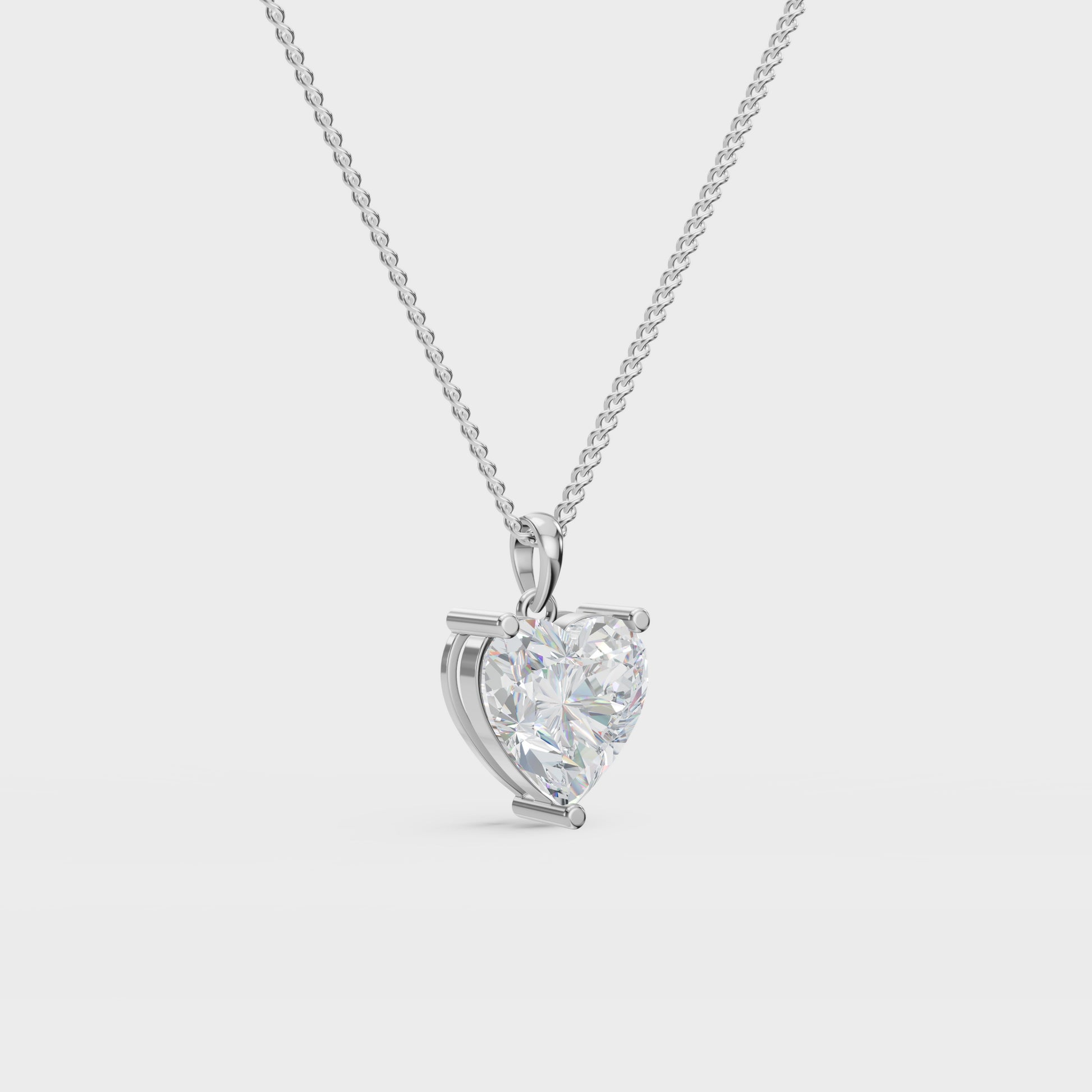 Heart-shaped diamond pendant on a chain against a light gray background