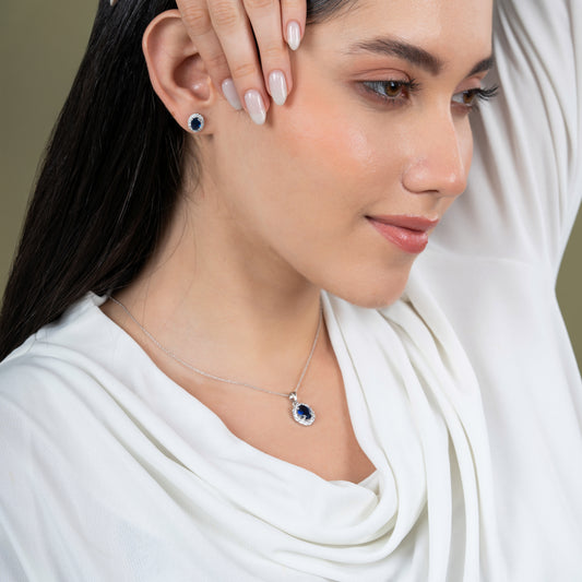 Woman wearing a necklace and earrings with a neutral background